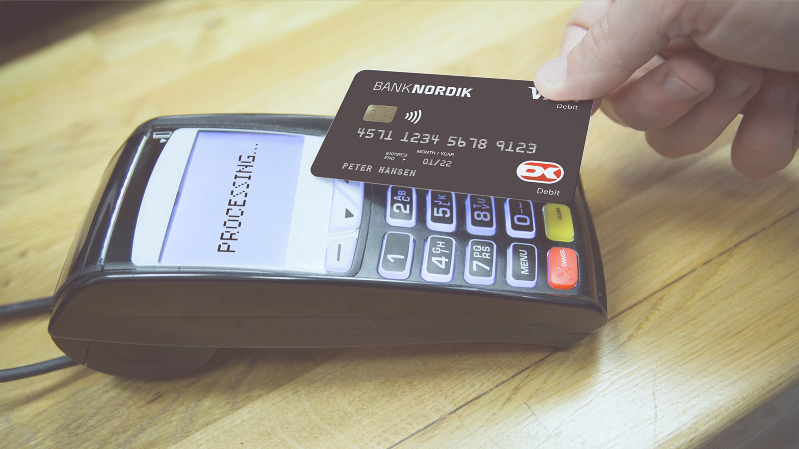 En mand betaler kontaktløst med sit BankNordik dankort