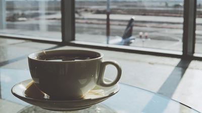 En kop kaffe står på et bord i en lufthavnsterminal