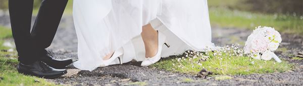Et brudepar står på stien i en skov
