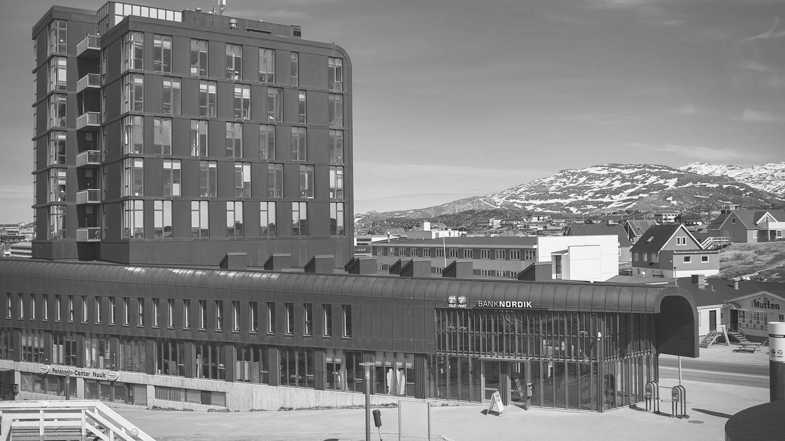 filialen Nuuk med et bjerg i baggrunden.