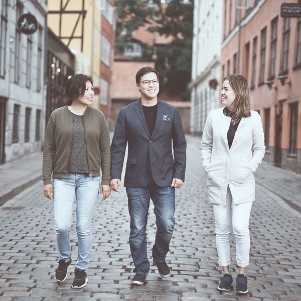 Tre unge mennesker går midt på en gade. 