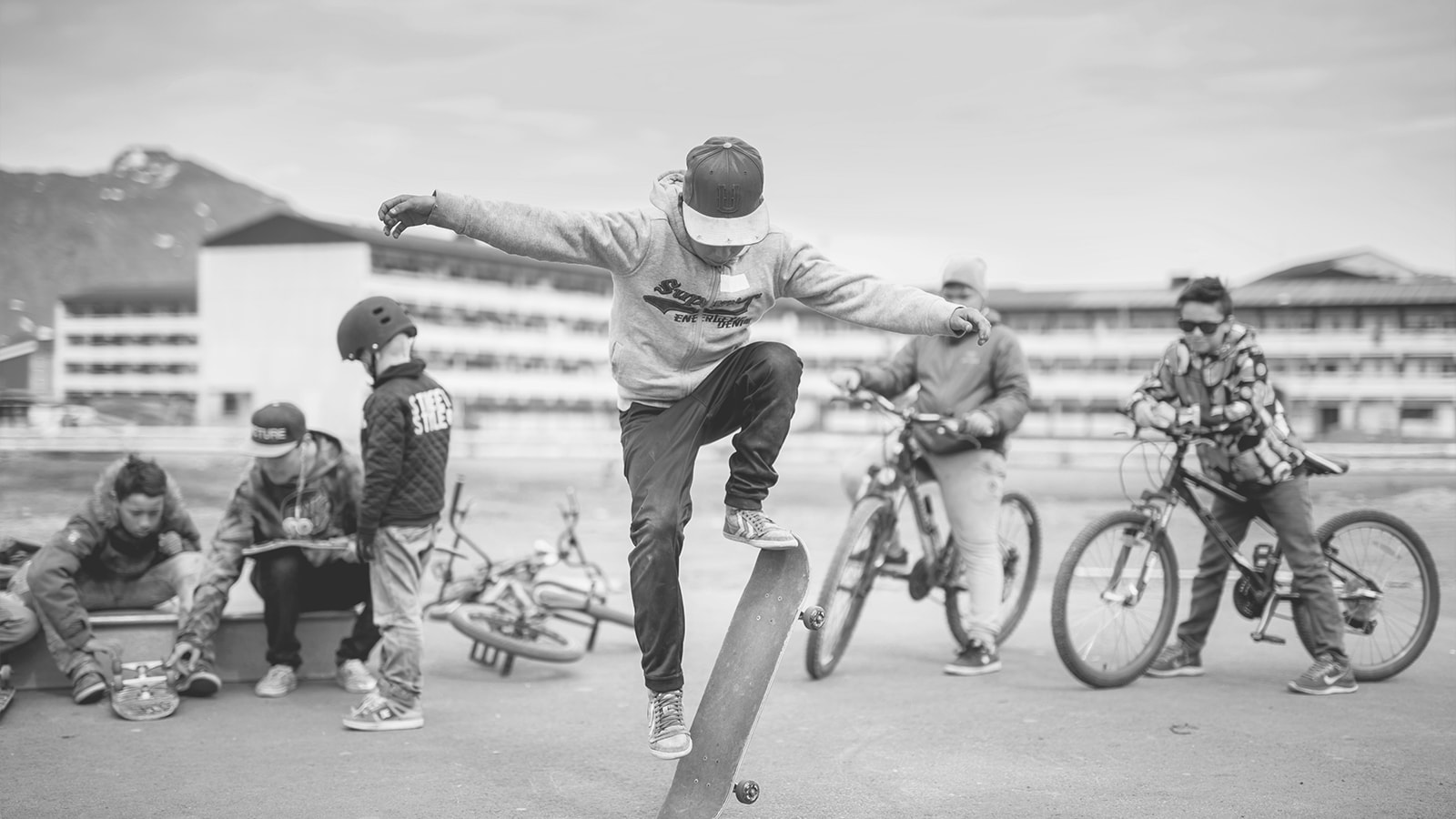 Unge drenge hænger ud på en sketarplads ned deres cykler og skateboard. 
